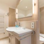 Bathroom with sink, mirror, and toilet.