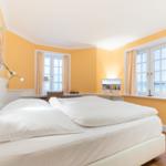 Bedroom with bed, windows, and wall art.
