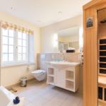 Bathroom with bathtub, toilet, sink, and sauna.