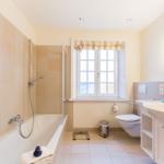 Bathroom with bathtub, shower, sink, and toilet.