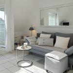 Living room with sofa, mirror, and balcony access.