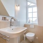 Bathroom with sink, toilet, and window.