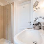Bathroom with shower, sink, and mirror.