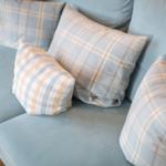Blue sofa with checkered cushions in light colors.