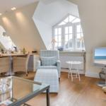 Living and dining area with TV, window, and wooden floor.