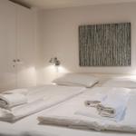 Bedroom with double bed, white bedding, and wall art.