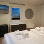 Bedroom with double bed, window, TV, and wardrobe.