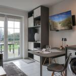 Living area with desk, TV, and view of the terrace.
