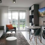 Living area with sofa, armchair, and TV. Doorway to garden. Washing machine in room.