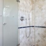 Shower enclosure with glass door and mosaic tiles