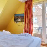 Bedroom with double bed, TV, and balcony view