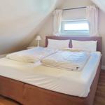 Bedroom with double bed, window, and nightstands.