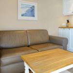 Leather sofa and wooden table in living area with kitchenette
