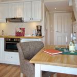 Kitchen with dining area, white cabinets, and wooden table with chairs.