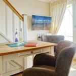 Dining table with two chairs, TV, and balcony door with view.
