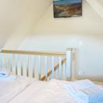 Bedroom with double bed, towels, and TV mounted on the wall.