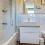 Bathroom with bathtub, shower, sink, and toilet.