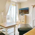 Living room with TV, table, and access to balcony.