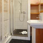 Badezimmer mit Dusche, Waschbecken und Heizkörper