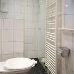 Bathroom with toilet, shower, and heater
