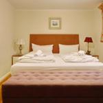 Double bed with white bedding and two nightstands with lamps.