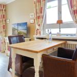 Dining table with two chairs by window with curtains