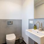 Bathroom with toilet, sink, and mirror