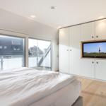 Bedroom with bed, TV, and balcony view.