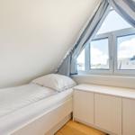Ein Schlafzimmer mit Einzelbett, Fenster und Schrank.