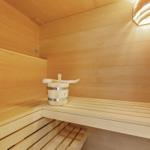 Sauna mit Holzbank und Eimer mit Löffel