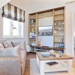 Wohnzimmer mit Sofa, Couchtisch und integriertem Bücherregal mit Fernseher.