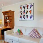 Living room with sofa, dining table, and wall art featuring coffee machine motifs.