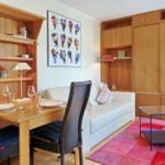 Living room with dining area, sofa, bookcase, and wooden furniture.