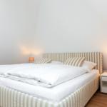 Bedroom with bed, nightstand, and lamps.