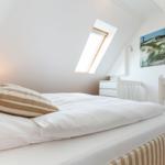 Bedroom with skylight, bed and wall picture