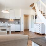 Apartment with kitchen, dining area, and staircase to upper level.