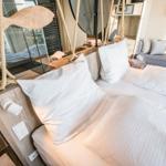 Schlafzimmer mit Bett, Kopfkissen und Fensterblick.