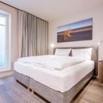 Schlafzimmer mit Doppelbett, Fenster und Wandbild