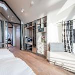Schlafzimmer mit Doppelbett, Sitzbank und integriertem Schrank.