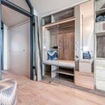 Schlafzimmer mit Glaswand, Holzmöbel und integriertem Schrank.