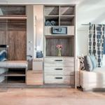 Schlafzimmer mit integriertem Schrank, Safe und Sitzbank.