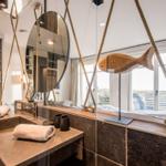 Badezimmer mit Seildekoration, Spiegel und Aussicht.