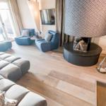 Wohnzimmer mit Sofa, Sesseln und Kamin