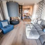 Wohnzimmer mit grauem Sofa, blauem Sessel und Kamin