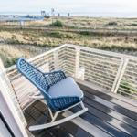 Terrasse mit blauer Schaukelstuhl und Meerblick.