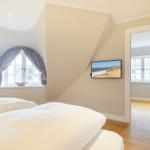 Schlafzimmer mit Dachschräge, Fenster und Fernseher