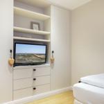 Schlafzimmer mit Bett, TV und Schrank