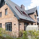 Haus mit Backsteinfassade und Holzterrasse im Garten