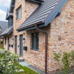 Haus mit Backsteinfassade und grauem Dach. Nummer 6 an der Wand.