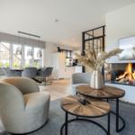 Wohnzimmer mit Kamin, Esstisch und moderner Einrichtung.